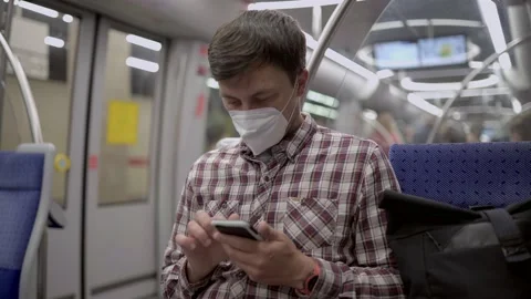 Masked passenger on subway in Munich uses 5G Internet on his smartphone. Self Stock Footage 219954740