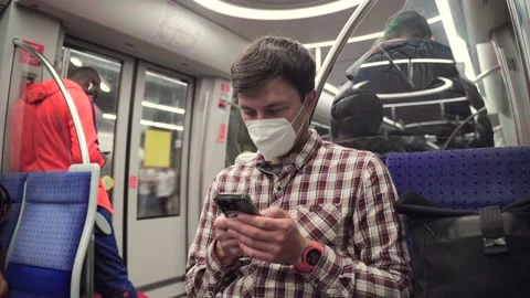 Masked passenger on subway in Munich uses 5G Internet on his smartphone. Self Stock Footage 219954769