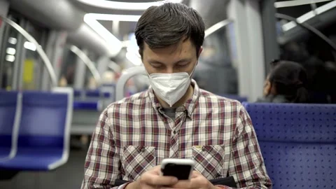Masked passenger on subway in Munich uses 5G Internet on his smartphone. Self Stock Footage 219954951