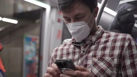 Masked passenger on subway in Munich uses 5G Internet on his smartphone. Self Stock Footage 219954979