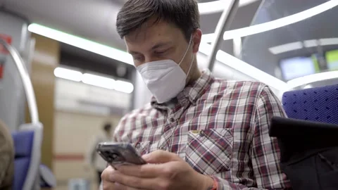 Masked passenger on subway in Munich uses 5G Internet on his smartphone. Self Stock Footage 219955145
