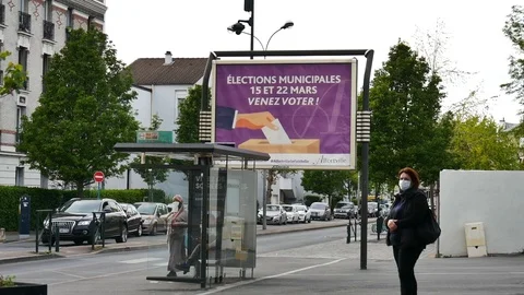 Masked people in front of elections panel paris suburb -COVID19 Stock-Footage 128605262