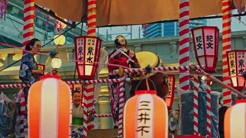 Masked Performer Playing Drum with Raised Arm on Festival Tower Stock Footage 345816832