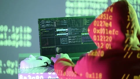 Masked programmer working on laptop with hex code and terminal windows under Stock Footage 307010156
