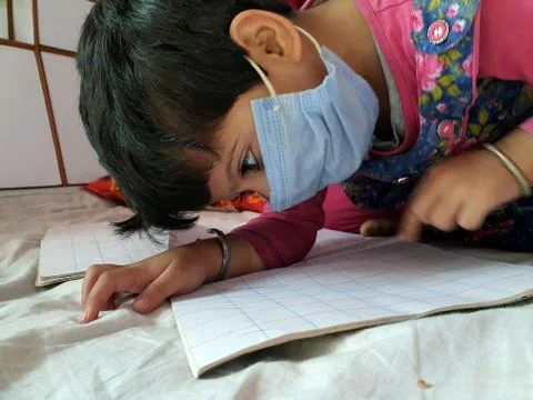 Masked School students are doing home work in home in covid-19 Stock Photos
