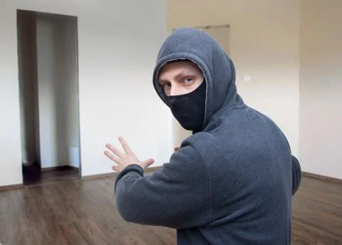 Masked thief in house Stock Photos