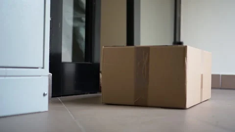 Masked woman picks up the box just delivered by courier. Contactless delivery Stock Footage 135166319