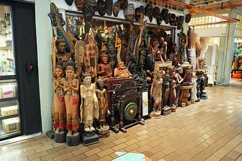 Masks and religious statues displayed outside a craft shop Stock Photos