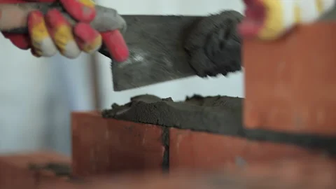 Mason applying mortar on red bricks with trowel Stock Footage 318411721