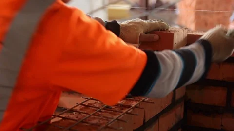 Mason makes a wall of red brick. Stock-Footage 103647532