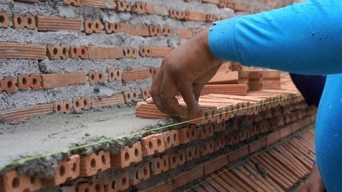 Mason plastering and placing brick to build wall construction Stock Footage 93275294