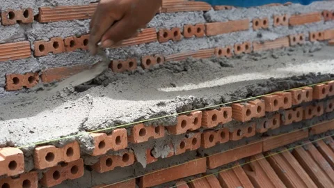 Mason plastering and placing brick to build wall construction Video stock 93275350
