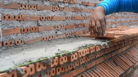 Mason plastering and placing brick to build wall construction Video stock 93275355