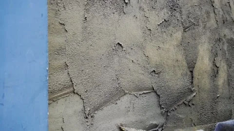 Mason plastering concrete wall with cement mortar using trowel Stock Footage 340543364