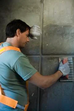 Mason with trowel pausing work, back of hand held to forehead Stock Photos