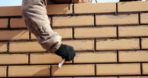 Mason wipes seam between bricks, builder, building concept, builds house Stock Footage 131004610