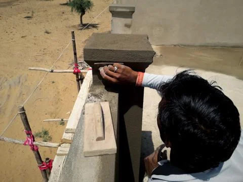 A mason at work making cement design on wall Stock Photos