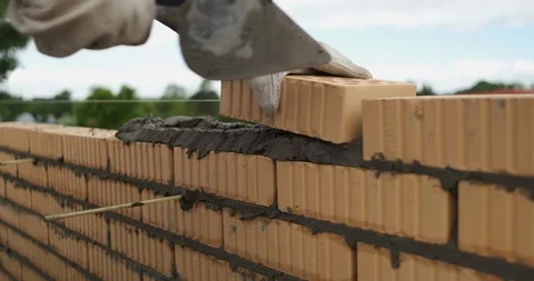 Mason work quickly, build wall of house, erect structure, put bricks in solution Stock Footage 117089499