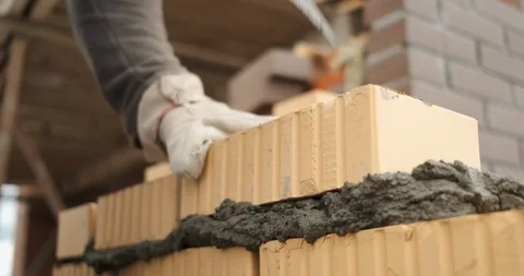 Mason work quickly, build wall of house, erect structure, put bricks in solution 動画素材 117090081