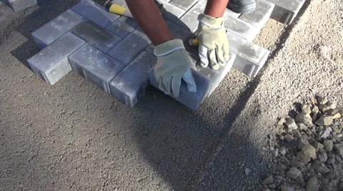 Mason worker making sidewalk pavement with stone bricks Stock Footage 29658643