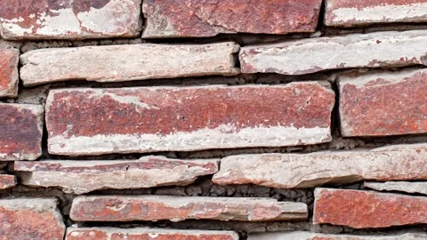 Masonry made of flat uneven red stones, wall with traces of red paint, movi.. Stock Footage 256331892