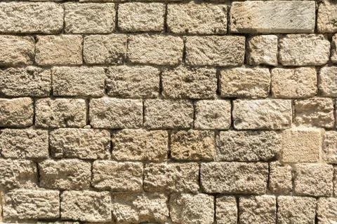 Masonry wall of old stone blocks of limestone Stock Photos