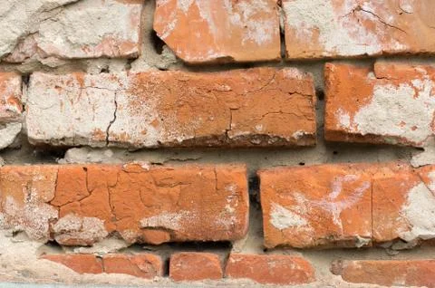 Masonry walls made of red bricks with traces of crumbling plaster Stock Photos