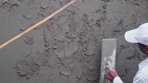 Masonry worker applying cement mortar on RCC Wall for plastering at Stock Footage 331764648