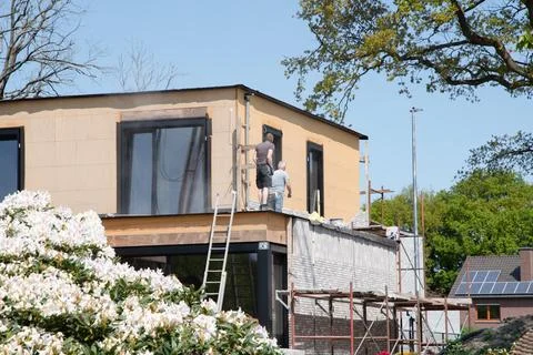 Masonry worker the bricklayer makes the facade of the house from gray bricks Stock Photos