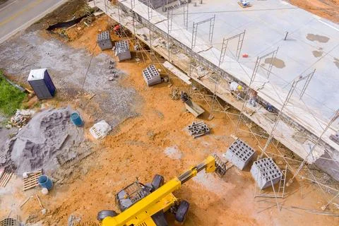 Masonry worker make concrete wall by cement block standing on a scaffolding at 스톡 사진