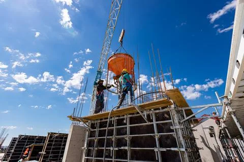 Masons fill up vertical mold with help of crane as carry cone tank for ceme.. Stock Photos