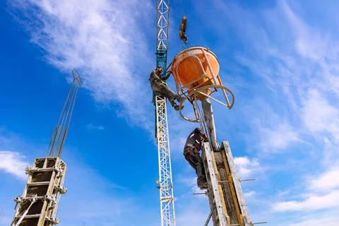 Masons fill up vertical mold with help of crane as carry cone tank for ceme.. Stock Photos
