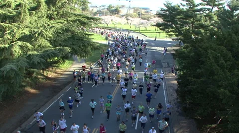 MASS OF RUNNERS TOWARDS CAMERA AND UNDER BRIDGE - SPORTFILM 10200R Video stock 50794381