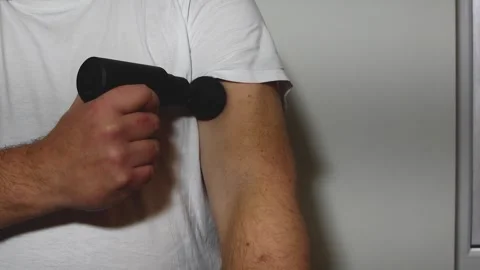 Massage of the arm in the biceps area with a massage gun. Self-massage of t.. Stock Footage 310497534