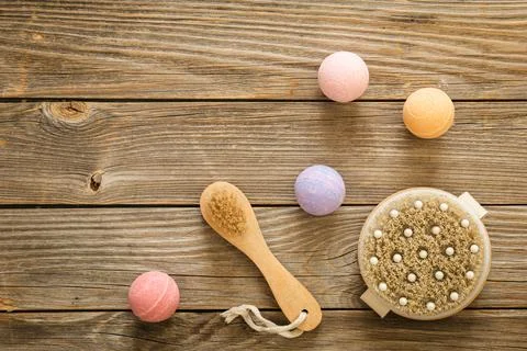 Massage brushes and bath bombs on a wooden background, top view. Stock Photos