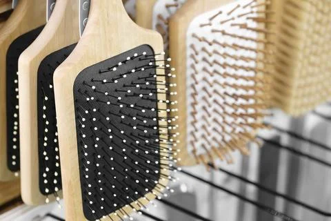 Massage combs hang on a display window in a market, close-up Foto stock