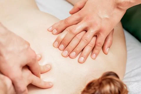 Massage with four hands. Stock Photos