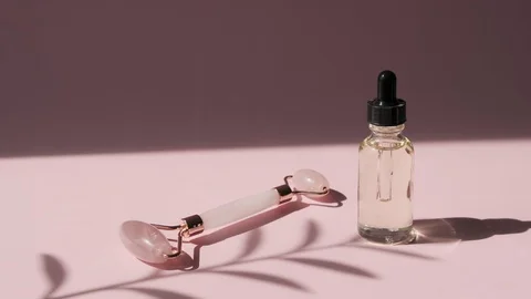 Massage quartz roller for face of pink natural nephritis with beauty serum oil. Stock-Footage 128248560