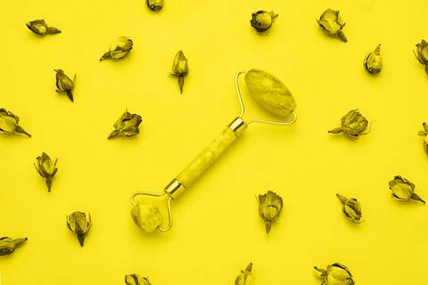 Massage roller for face with two jade stones on yellow background. Health care Stock Photos