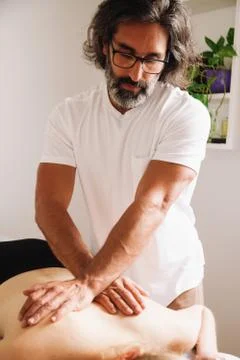 Massage session. Caucasian man performing massages Stock Photos