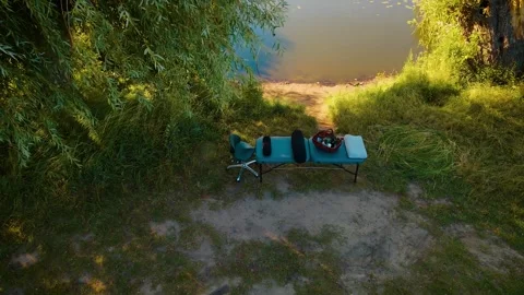 Massage table placed near river under tree in peaceful setting for relaxation Stock Footage 308311519