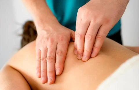 Massage therapist doing massage of trigger points in the back Stock Photos