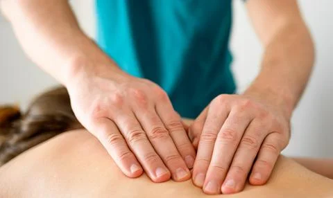 Massage therapist doing massage of trigger points on a back Stock Photos