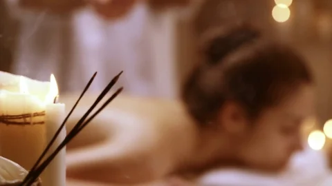Massage therapist dredge salt on girl lying on table in spa resort. Concept of Stock Footage