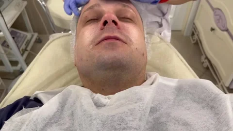 Massaging a man's face in a spa salon Stock Footage 244814293