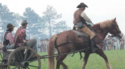 Massed soldiers as cannon and riders pass in foreground Stock Footage 39982953