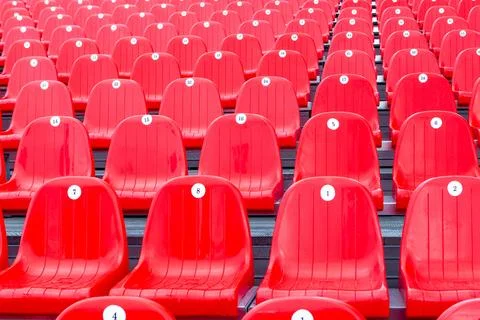 Masses of empty plastic red chairs or seats in a school assembly hall Stock Photos
