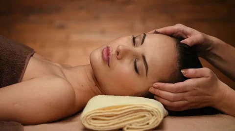 Masseur doing massage of the temples and stroking hairs for an woman in spa s Stock Footage 47372744