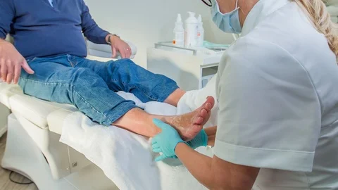 Masseur is gently massaging a middle-aged man's feet in a massage studio. 動画素材 122089166