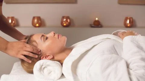 The masseur gives a facial massage to a pretty woman. Spa Stock Photos